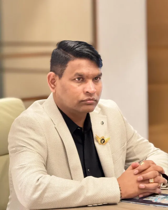 Dr. Rajendra Upadhye seated at a desk in a beige blazer