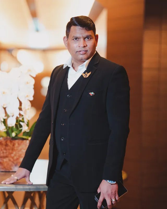 Dr. Rajendra Upadhye standing beside a table with white orchids