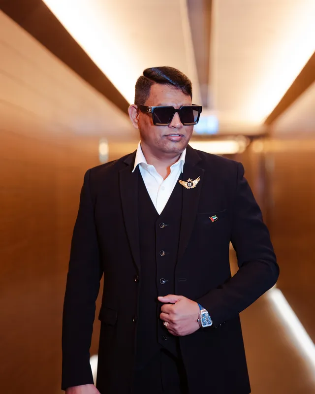 Dr. Rajendra Upadhye in a black suit in a lit corridor