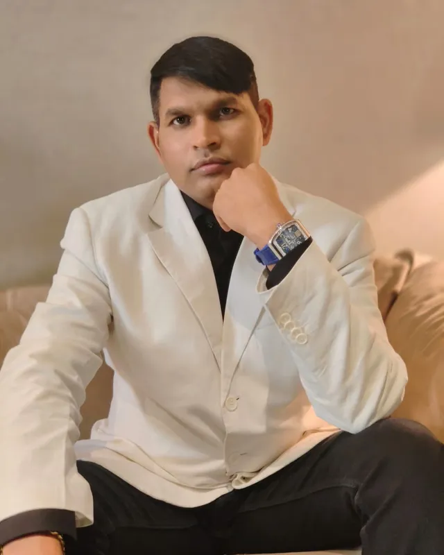 Dr. Rajendra Upadhye in a white blazer, seated