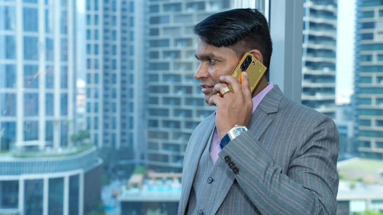 Dr. Rajendra Upadhye on a call, city towers behind him
