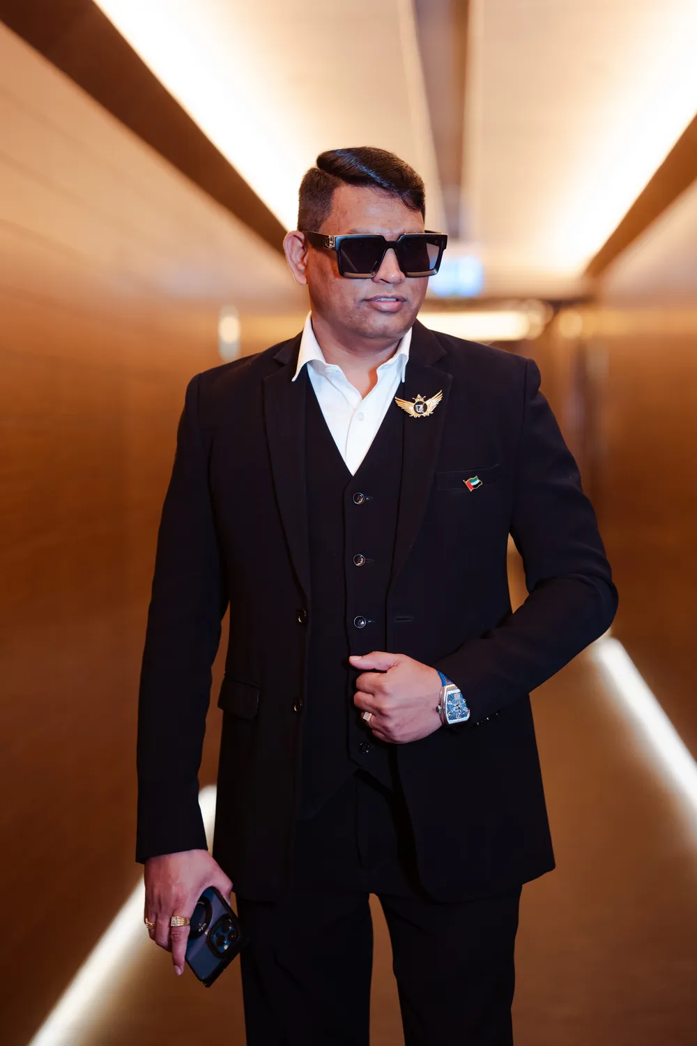 Dr. Rajendra Upadhye in a black suit in a lit corridor
